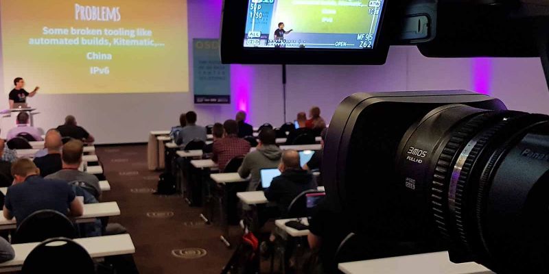 Digitalkamera mit ausgeklapptem Display für den Mitschnitt eines Vortrages bei einer Tagung